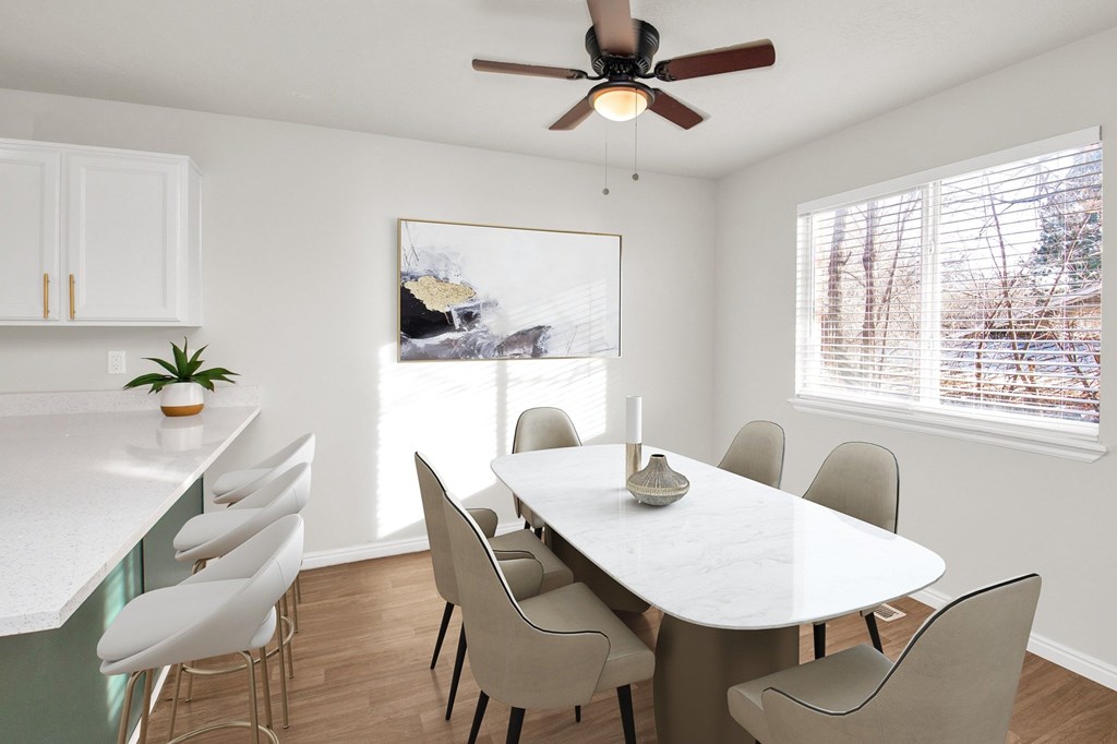 A dining room with a white table and chairs.