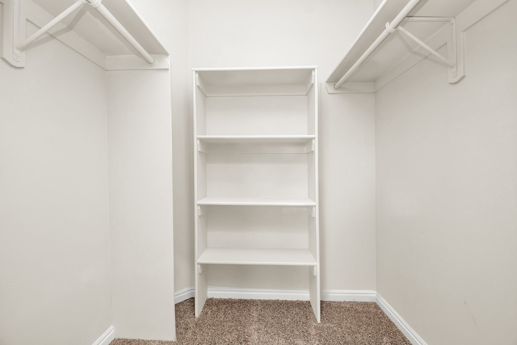 A white shelving unit in a room with white walls.