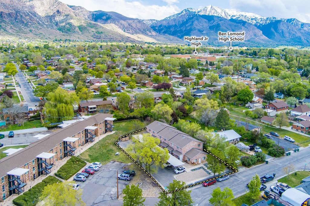 A high school is located in a residential area with mountains in the background.