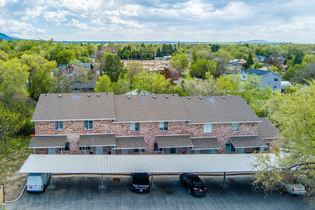 A large house with a grey roof and a covered parking area.