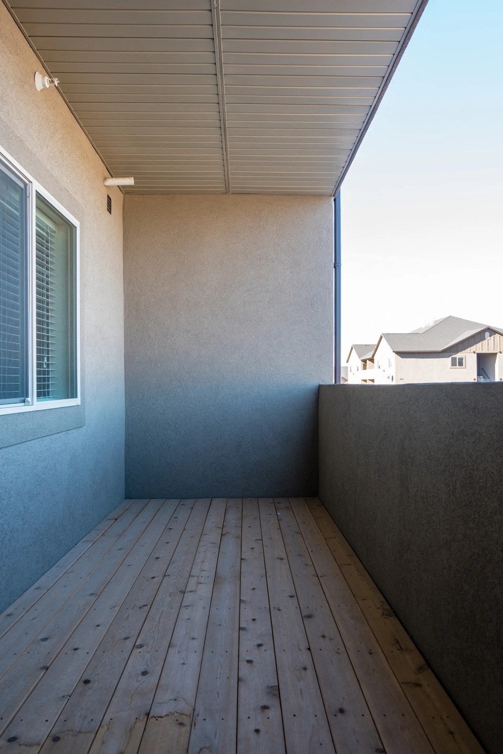 the deck on the back of the house has a wood floor and a blue wall