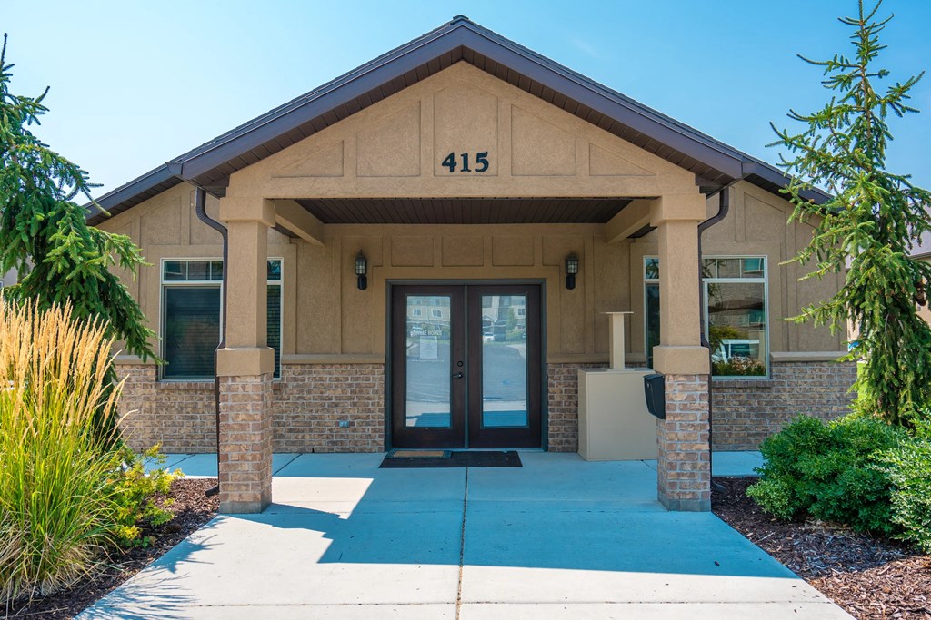 the front of a brick building with a blue sidewalk and doors
