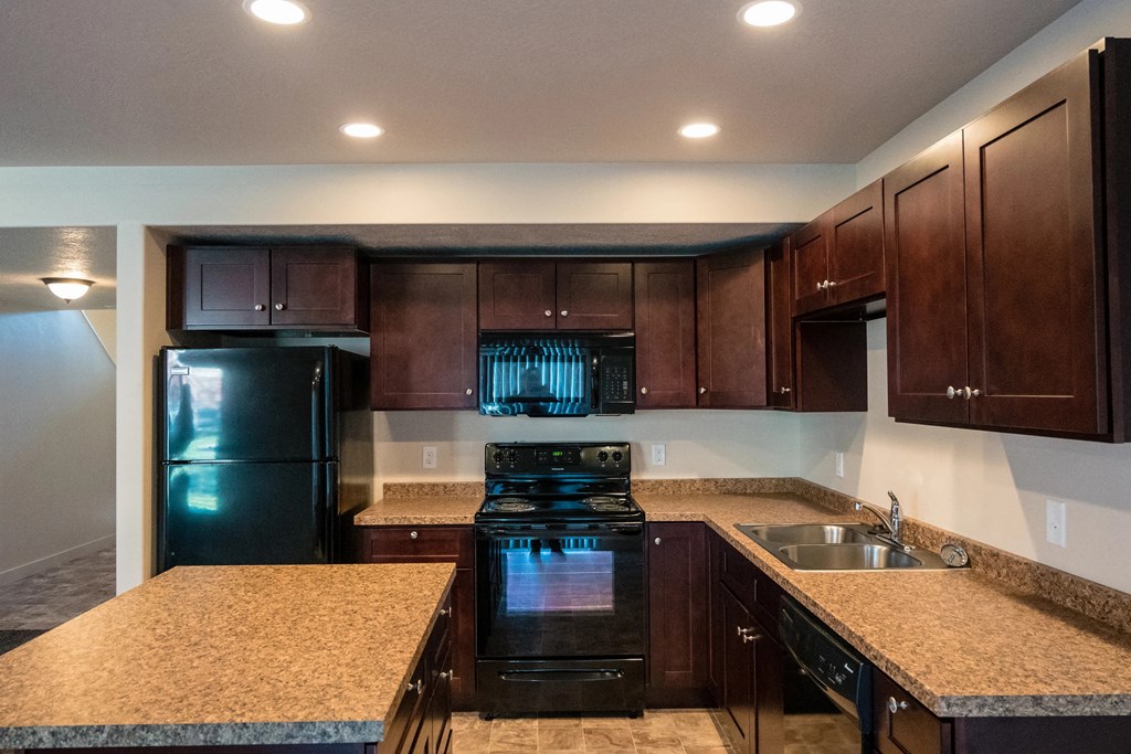 a kitchen with black appliances and granite counter tops