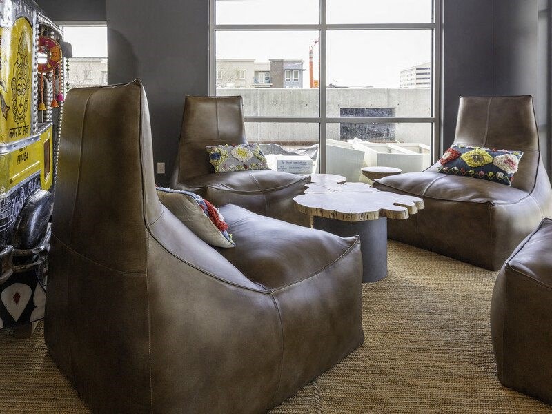a living room with leather chairs and a window