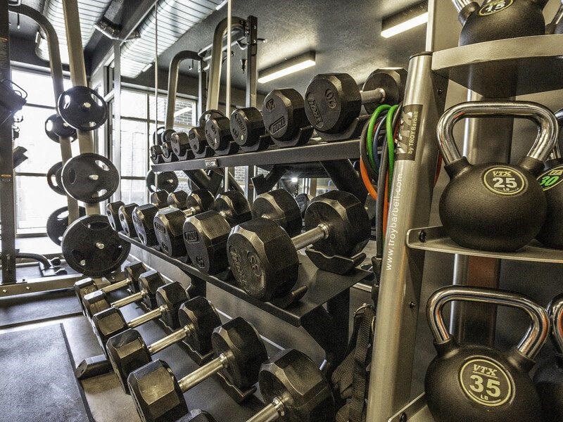 a gym with weights on a rack in the middle