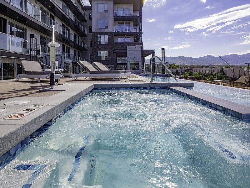 a pool with people swimming in it next to a building