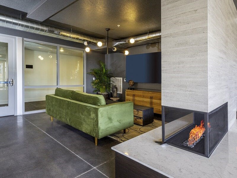 a living room with a fireplace and a green couch