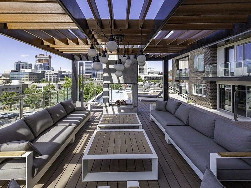 a patio with couches and tables on a roof
