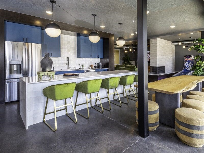 a kitchen with green bar stools and blue cabinets