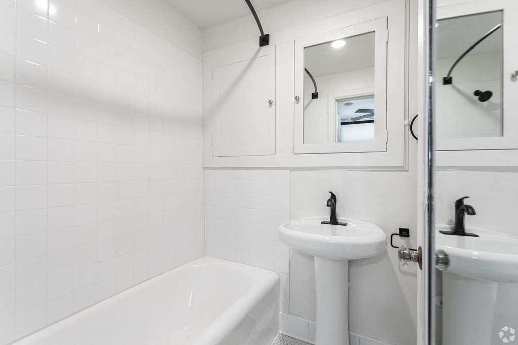 a bathroom with a sink and a tub and a mirror