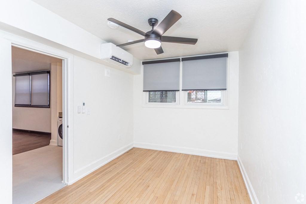 an empty room with a ceiling fan and a window