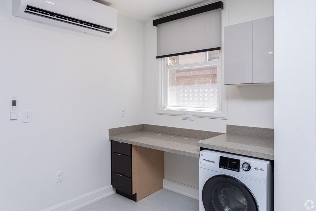 an empty kitchen with a washing machine and a window