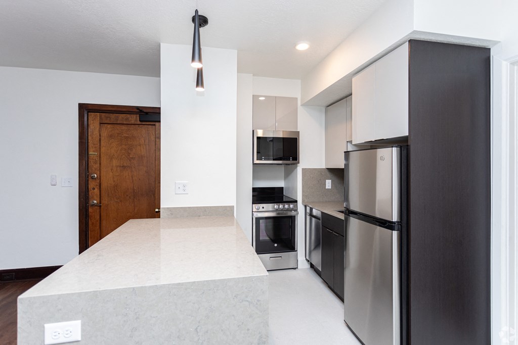 a kitchen with stainless steel appliances and a white counter top