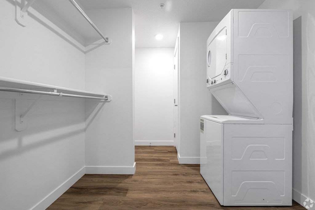 a white laundry room with a washer and dryer and a wood floor at Lotus Gallacher luxury apartments for rent in Salt Lake City, UT