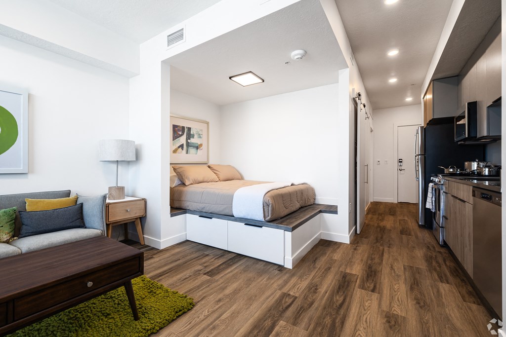 a bedroom with a bed and a couch in a small room at Lotus Gallacher luxury apartments for rent in Salt Lake City, UT