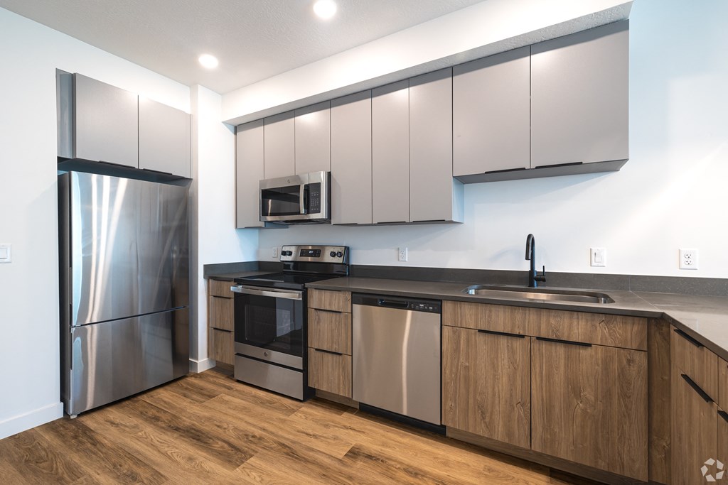 a kitchen with white cabinets and stainless steel appliances at Lotus Gallacher luxury apartments for rent in Salt Lake City, UT