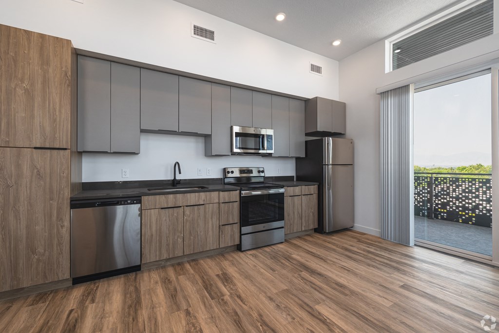 a modern kitchen with stainless steel appliances and wooden cabinets at Lotus Gallacher luxury apartments for rent in Salt Lake City, UT