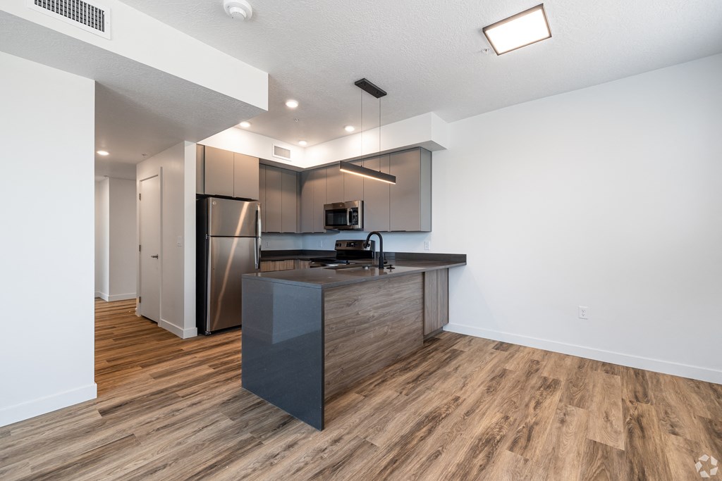an open kitchen with a large island and stainless steel appliances at Lotus Gallacher luxury apartments for rent in Salt Lake City, UT