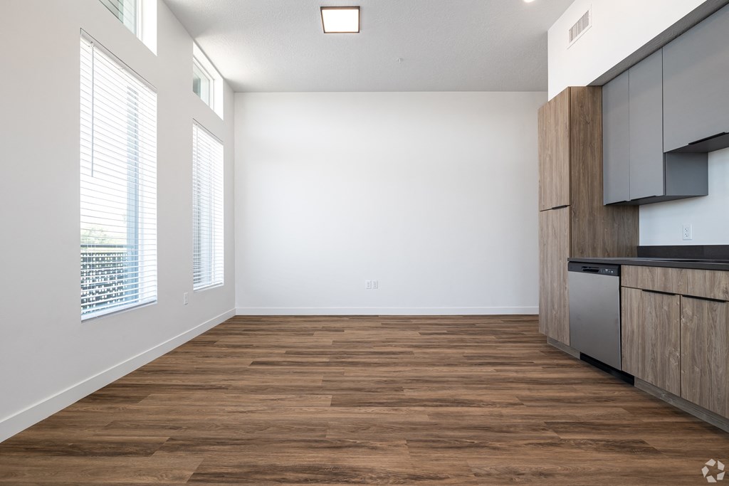 an empty living room with wood flooring and a kitchen at Lotus Gallacher luxury apartments for rent in Salt Lake City, UT