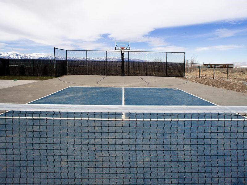 A tennis court with a net and a fence.