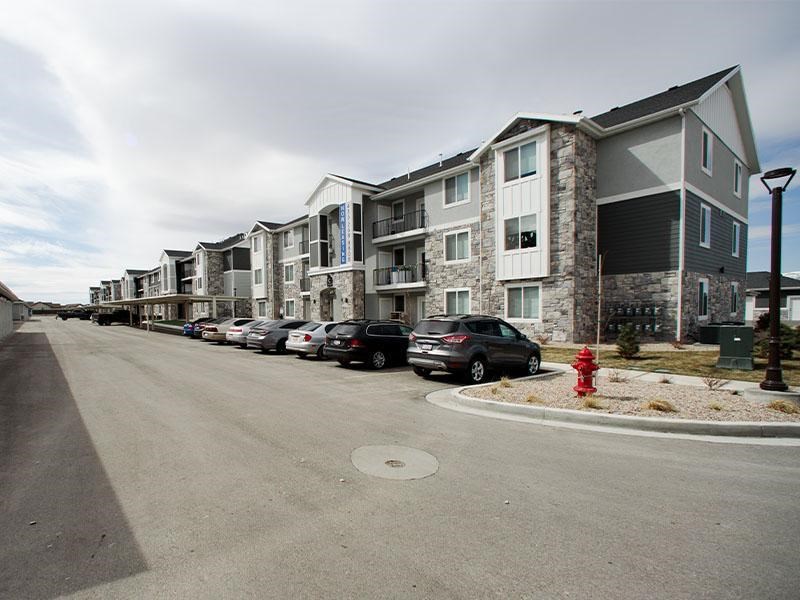 A row of houses with cars parked in front.
