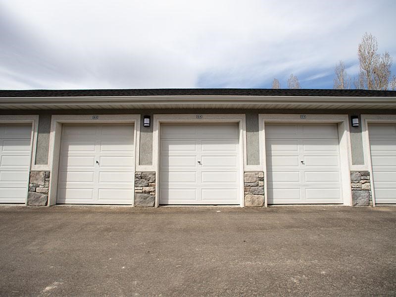A row of four white garage doors are closed.