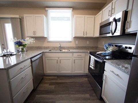 A kitchen with white cabinets and a black stove top oven.