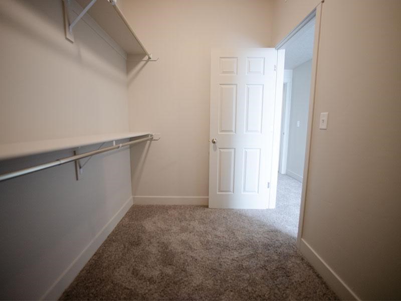 A white door is in a room with a grey carpet.