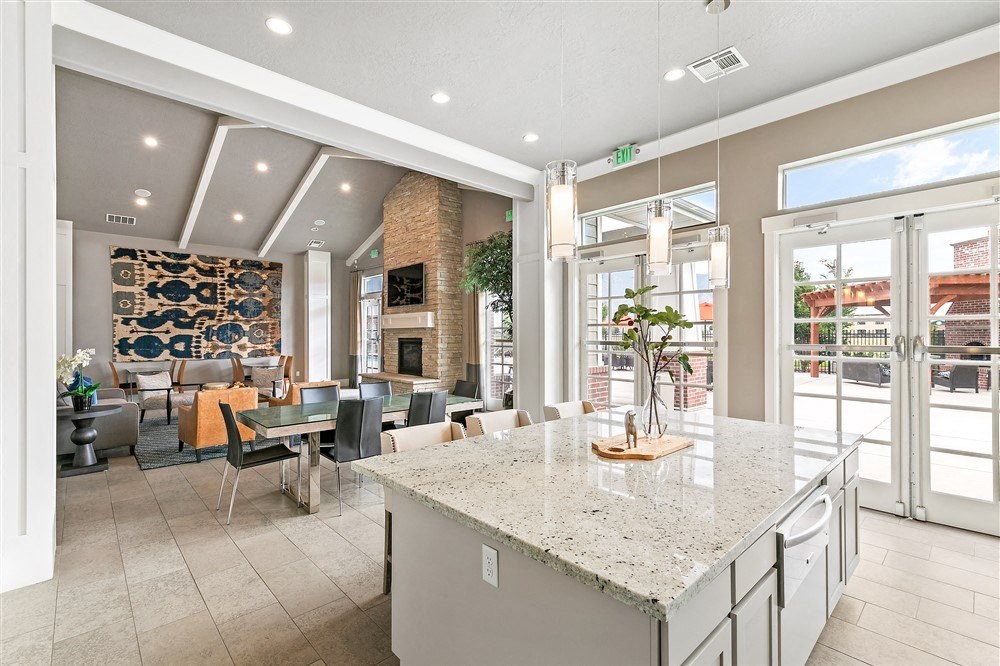 a bright and modern clubhouse with couches, chairs, and a kitchen with marble counter tops at Outlook Apartments for rent in Springville and Provo, UT.