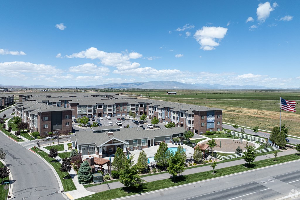 an aerial view of an apartment complex with a pool and flag at Outlook Apartments for rent in Springville and Provo, UT.