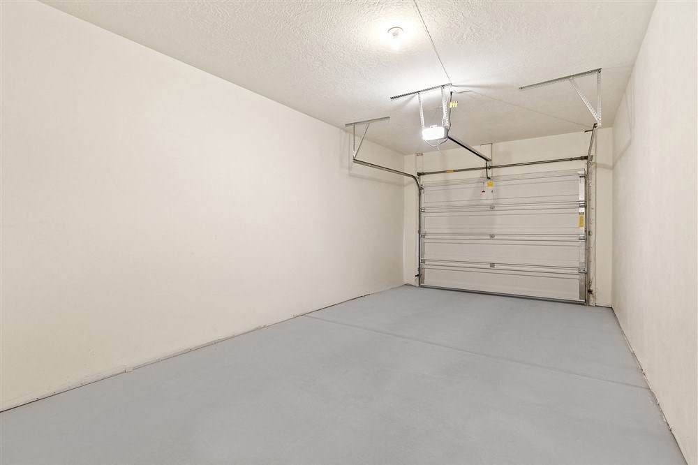 the interior of a garage with a white wall and a garage door at Outlook Apartments in Springville and Provo, Utah
