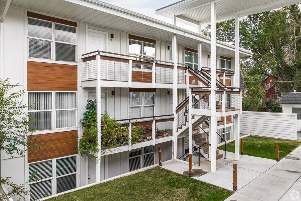 A white building with a balcony and stairs.