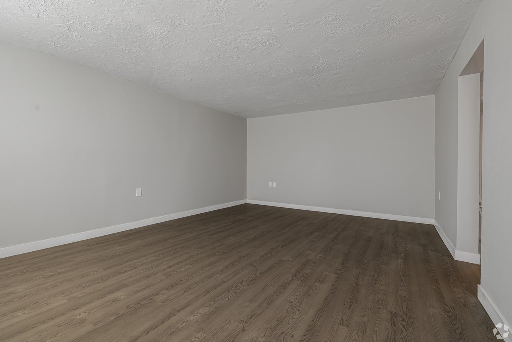 A room with wooden flooring and white walls.