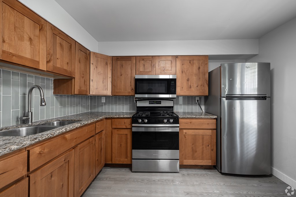A kitchen with wooden cabinets and stainless steel appliances.