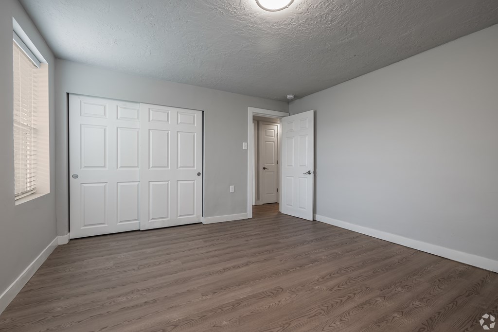 A room with a white door and a wooden floor.