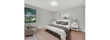A bedroom with a bed, nightstand, and chair.