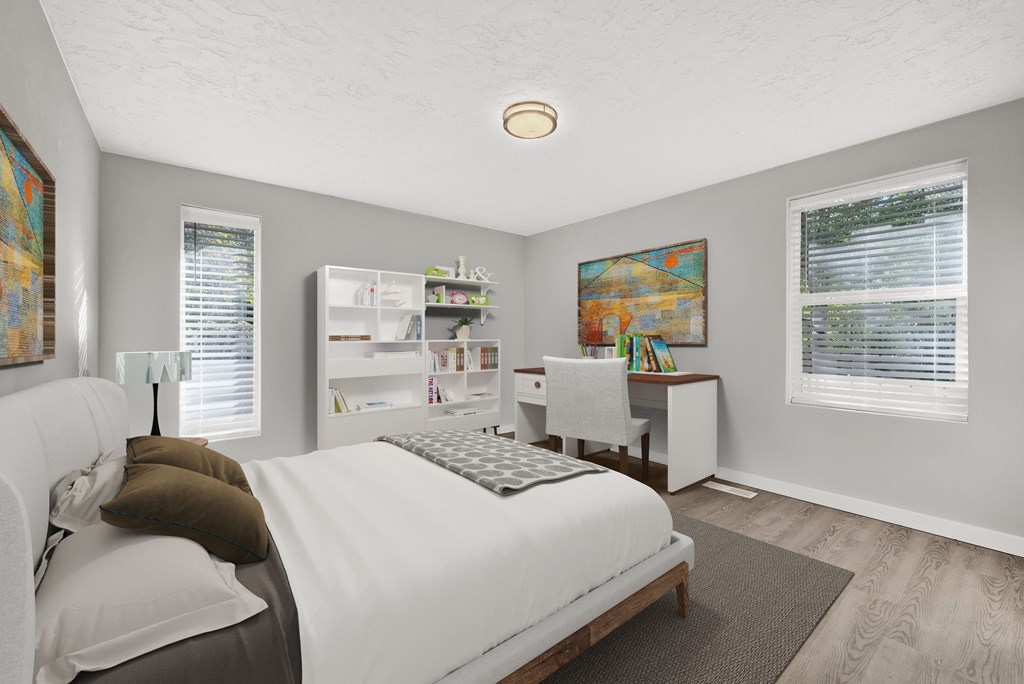 A bedroom with a bed, desk, and a painting on the wall.