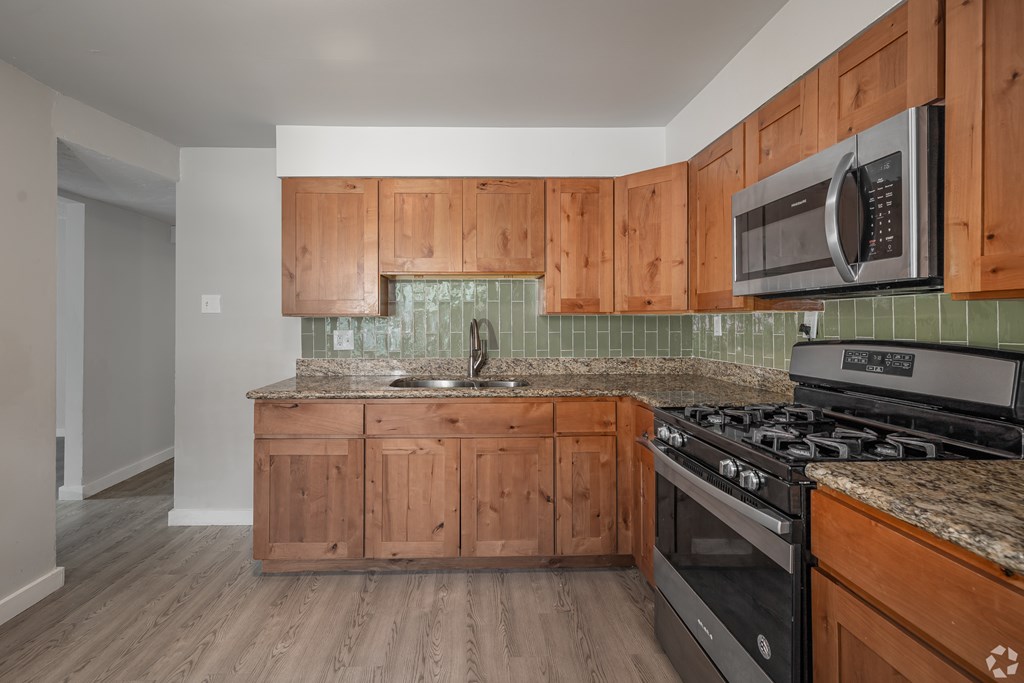 A kitchen with wooden cabinets and a black stove top oven.