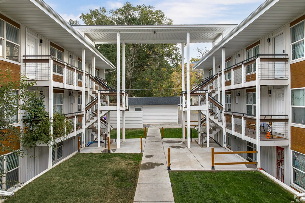 Apartment complex with a white roof and a green lawn.