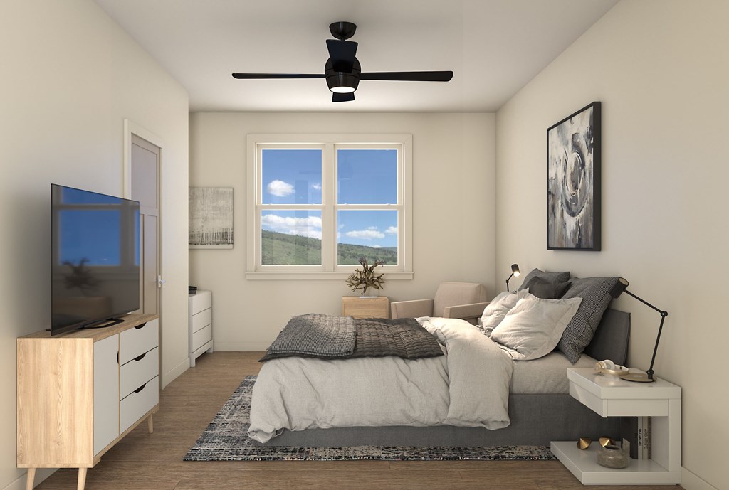 A bedroom with a bed, a television, and a window.