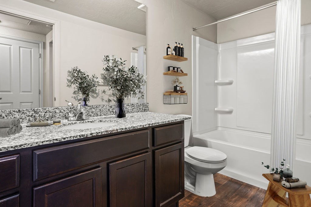 A white bathroom with a dark brown vanity.