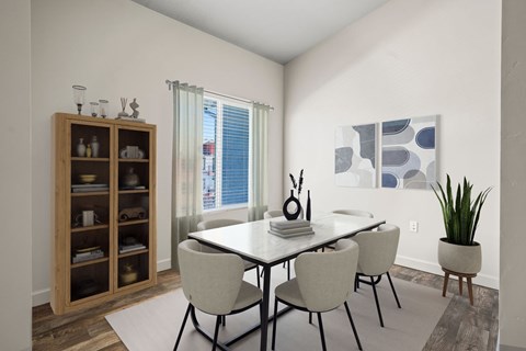 A dining room with a table and chairs.