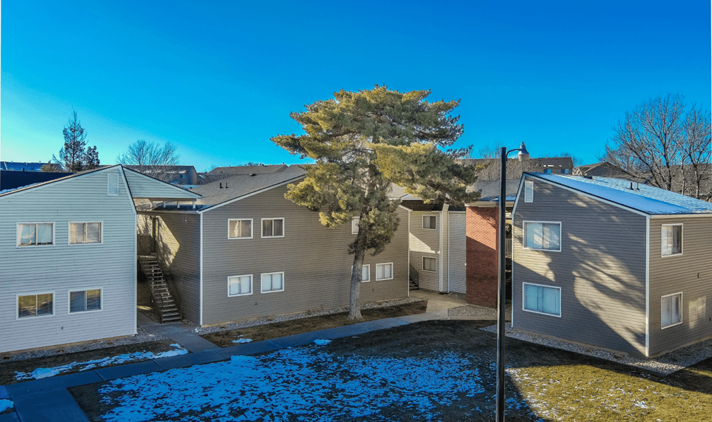 A row of houses with a blue tarp covering the ground.