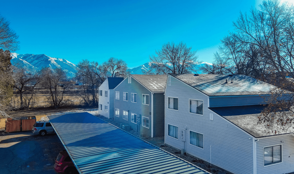A house with a grey roof and a car parked in front.