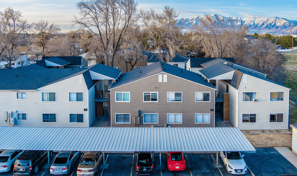 A parking lot with cars and a building in the background.