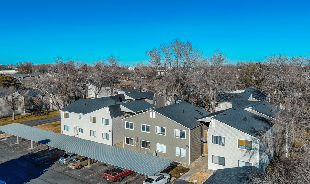 A large apartment complex with a parking lot in front.