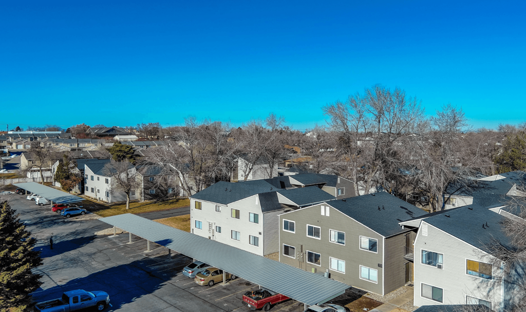 A parking lot with cars and a building in the background.