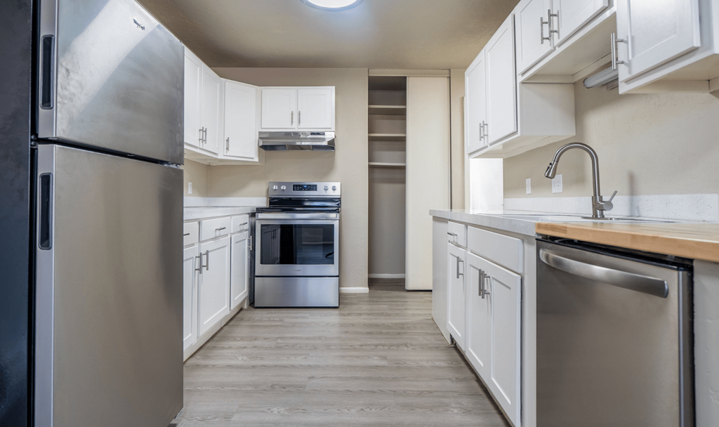 A modern kitchen with stainless steel appliances and white cabinets.