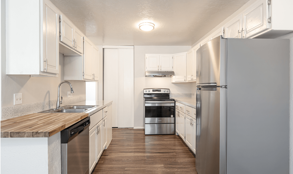 A kitchen with white cabinets and stainless steel appliances.