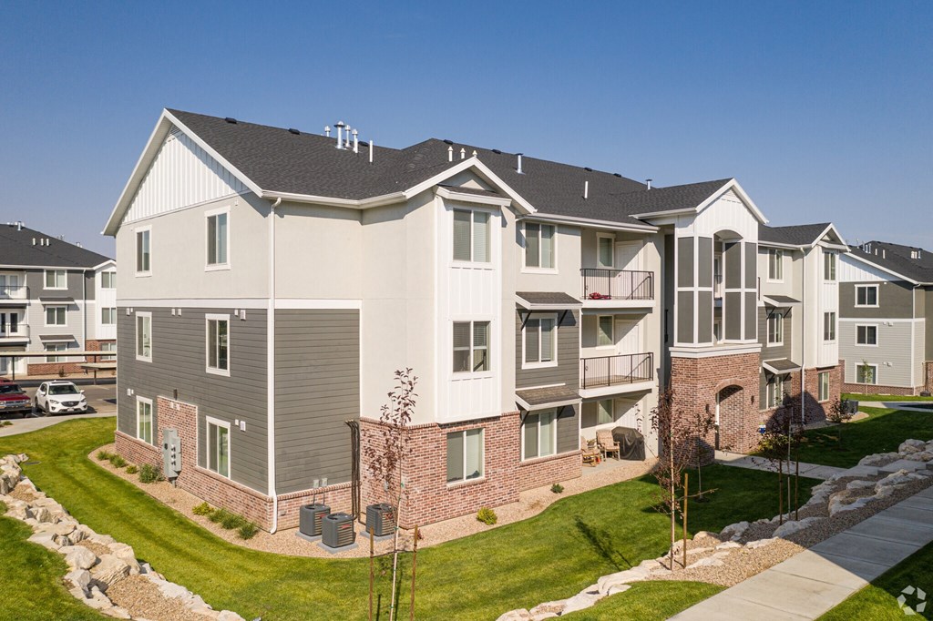 A large, modern apartment building with a mix of brick and siding exteriors.